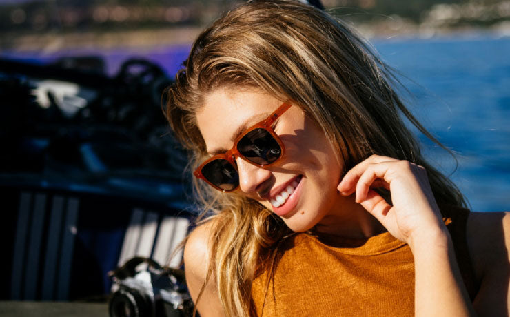 Stylish woman in adventure-ready sunglasses from Roark, perfect for travel and outdoor activities, featuring durable eyewear for vision care.